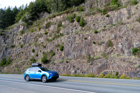 Road trip in car along mountain wall in Oregon, USA