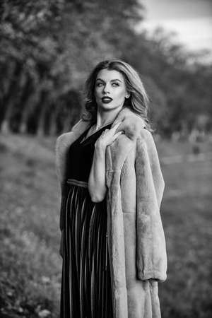 go smarter. Eco-Friendly. best luxury clothing material. lady looking trendy walk in street. comfortable and warm. complement your outfit. modern winter fur coat. elegant woman red lips wear fur coatの写真素材