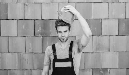 Worker brick wall background. Building construction. General maintenance repair worker fix maintain building. Inspect diagnose problems figure out way correct. Man build house. Inspecting buildingの写真素材