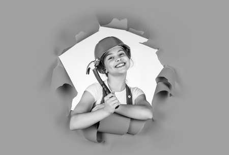 Child care development. Kid engineer with carpenter work hammer. Labor day at 1 may. little girl in hard hat holds hammer. best repairer ever. learning to use hammer. hammering. she is good assistantの写真素材