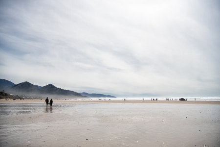 cannon beach landscape, oregon usa. summer vacation. people walking on beachの写真素材