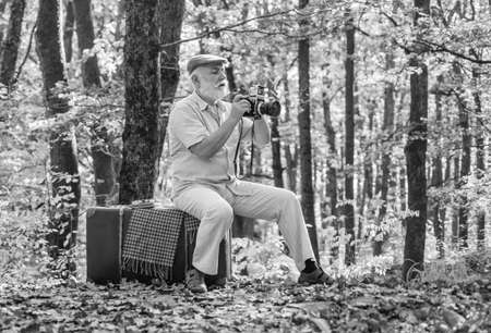 Used to manual settings. Old man shoot in nature. Landscape and nature photo shooting. Old photographer filming. Cameraman outdoors. Professional photographer. Pension hobby. Retro photographerの写真素材