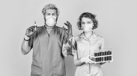 laboratory experiment. stop avirus. virus infection injection vaccine. doctors respirator mask. for treating patients. laboratory testing tubes. Doctor in medical mask ready to make injectionの写真素材