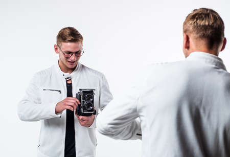 young twin brothers photographer with similar appearance make photo with retro camera, photographyの写真素材