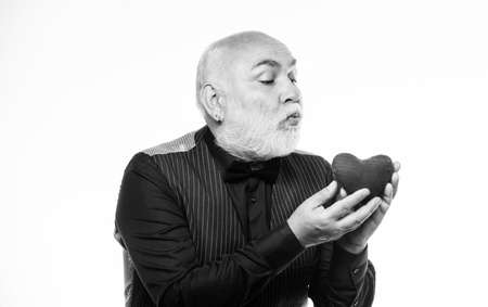kiss love. bearded man has heart failure. love and romance. happy mature man hold red heart. Health care and treatment. problems with heart. valentines day. donor transplantの写真素材