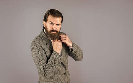 stylish mature man looking modern. mens jacket wardrobe. fashionable man dressed in suit. formal fashion model. handsome man standing on gray background. serious bearded businessman. copy spaceの写真素材