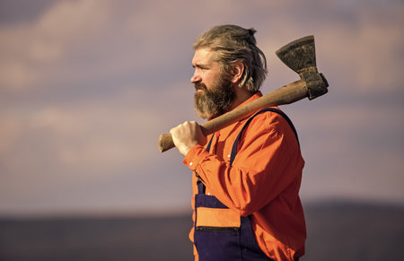 lets start working. Skilled architect repair and fix. engineer career. bearded man in uniform. mature man builder use axe. professional repairman working with ax tool. build and constructionの写真素材