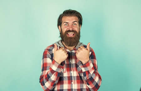 show thumb up. mature bearded man in plaid shirt. handsome man wearing checkered shirt on yellow background. male beauty and fashion. confident and strict man in casual checkered shirtの写真素材
