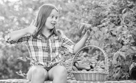 Gmo free. Eco farming. Girl cute smiling child living healthy life. Healthy lifestyle. Kid gathering vegetables nature background. Healthy homegrown food concept. Eat healthy. Summer harvest conceptの写真素材