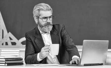 Watch video for step by step tutorial. Handsome man use modern technology. Digital technology. School teacher with laptop. Web development. Teacher teaching programming language. Teacher at classroomの写真素材