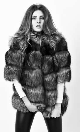 Fur fashion concept. Winter elite luxury clothes. Female brown fur coat. Fur store model posing in soft fluffy warm coat. Pretty fashionista. Woman makeup and hairstyle posing mink or sable fur coatの写真素材