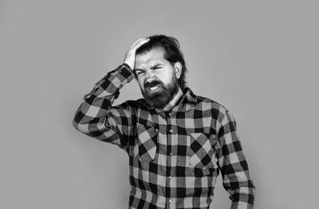 feeling bad. bearded man in checkered shirt. casual guy express human emotions. hipster with long hair and moustache has headache. male beauty and fashion. migraine concept. suffer from painの写真素材