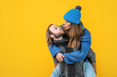 kiss me sweetie. christmas fun. knitted fashion. man and woman in sweater hat and scarf. happy...