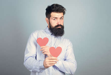 Man bearded hipster with heart valentine card. Celebrate love. Guy attractive with beard and...