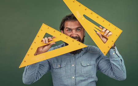 man with beard and moustache look as businessman or teacher in college or school, triangle toolの写真素材