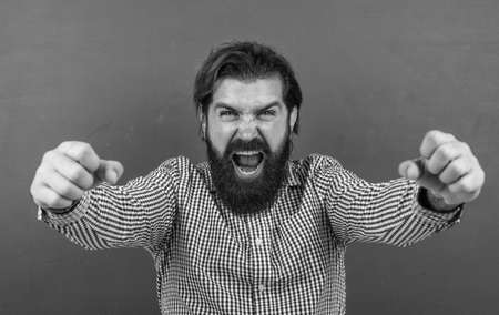 caucasian hipster on green background. happy mature teacher on background of blackboard. brutal bearded man wear casual checkered shirt. celebrating success. express bright human emotionsの写真素材