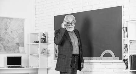 Back to school. Teacher old school generation. Experienced lecturer. Mature man enjoying job. Teacher going to continue embracing new roles and responsibilities. Senior man teacher at chalkboardの写真素材