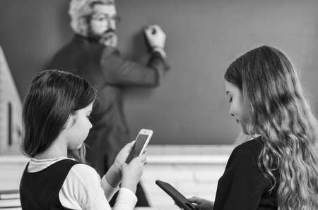 Preparing to exams. Discussion of children and teacher. Teacher and Child Learning at Classroom. study together is cool. back to school. help and support. Elementary Pupil With Teacher In Classroomの写真素材