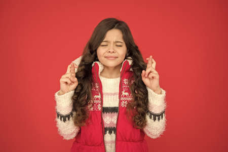 teen girl with long curly hair make a wish wear puffer waistcoat and sweater with christmas...