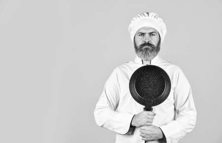 Healthy food cooking. cooking tasty dish. bearded man hold frying pan. Cooking in pot. for preparing food. Bearded man cooking in kitchen. culinary and cuisine. Kitchen utensils. copy spaceの写真素材