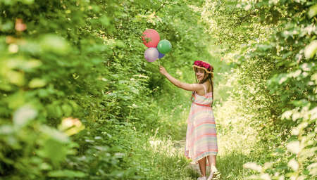 carefree. girl with rose flowers in hat. green nature. happy teen girl in straw hat.の写真素材