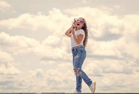 Funky style beauty. music is my life. kid sing with mic. cheerful event manager. child have fun on party. happy singer with microphone. classic cool. girl singing. vocal school concept. karaoke clubの写真素材