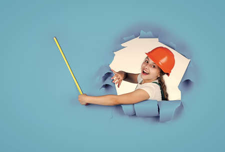 I can fix it. future engineer. happy kid use tape measure repairing tool. building construction site. child architect worker. labor day concept. childhood development. teenager girl assistantの写真素材