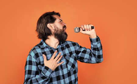 Music is the answer. male in karaoke. music and vocal concept. bearded man in checkered shirt with microphone. casual guy country singer. hipster with long hair and moustache sing songの写真素材