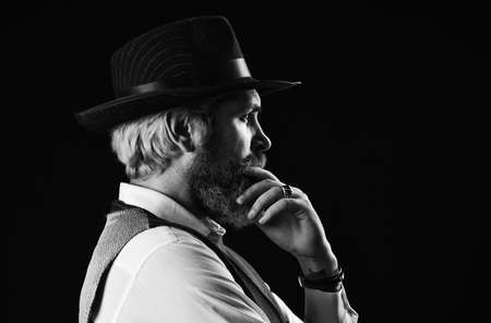 brutal bearded hipster in suit vest. mafia gentlemen club. mature cowboy. detective acknowledgement or greeting. trilby hat. man in vintage style wide brimmed hat. Man with retro Hat. copy spaceの写真素材