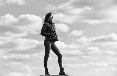 enjoys sunny day and blue sky. beauty and fashion. girl wear jacket in city street. Stylish fashion model outdoor. People freedom style. Winter Warm Clothing. girl wearing casual jeans clothesの写真素材