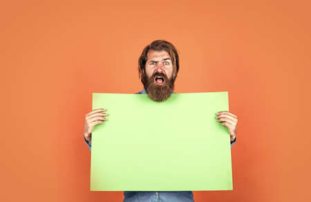 mature bearded guy has long hair hold paper placate, copy space, ideaの写真素材