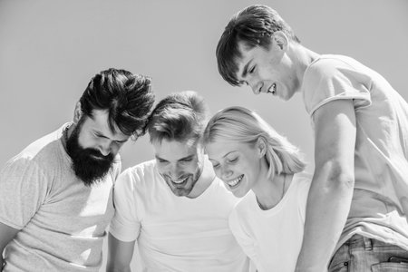 What is there. Group people excited look down. Woman and men happy sky background. Happiness in unity. Open mind for happiness. Carefree youth hang out together. See something adorable. Happinessの写真素材