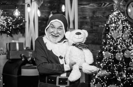 Christmas composition. holiday shopping online. cheerful santa man hold toys. teddy bear. bearded man love bear toy. merry christmas. happy new 2020 year. xmas gifts and presents. winter seasonの写真素材