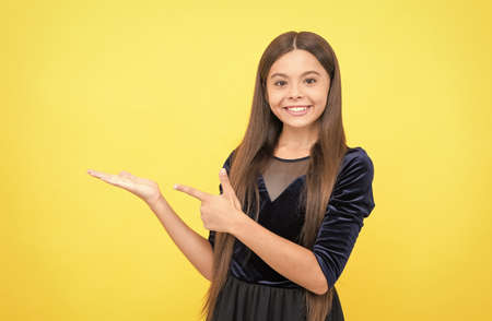 cheerful girl kid with happy face express positive emotions and presenting product, adの写真素材