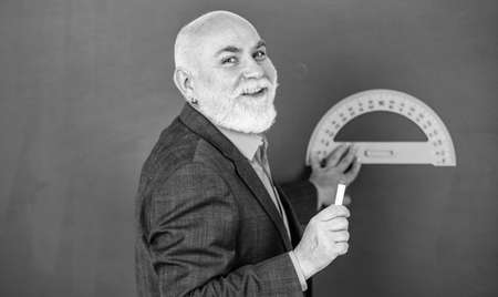 in good mood. bearded tutor man draw with ruler on blackboard. back to school. favorite subject and disciplines. Education and school concept. home learning. senior man teacher use protractor toolの写真素材