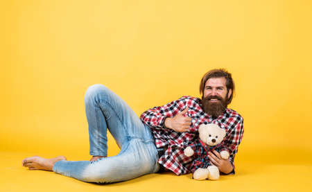 time to relax. happy birthday. being in good mood. happy valentines day. cheerful bearded man hold teddy bear. male feel playful with bear. brutal mature hipster man play with toyの写真素材
