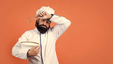 tired brutal hipster in apron finished cooking meal. time for eating. hard baking. concept of housekeeping. mature bearded man wear chef hat. male cook ready for preparing food. exhausted and tiredの写真素材