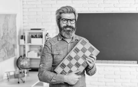 Management and leadership. Board game. Smart man playing chess. Intellectual hobby. Chess lesson. Strategy ideas. Teacher at tournament. Strategy concept. Every chess master was once beginnerの写真素材