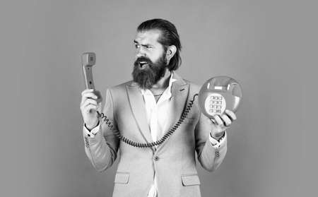 bearded man in formalwear speak on retro phone. elegant businessman has business talk. communication. true gentleman with groomed hair hold vintage telephone. nice conversationの写真素材