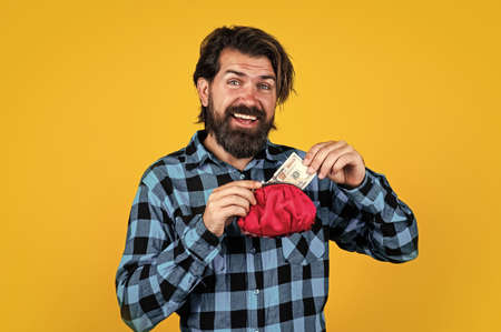 brutal man in checkered shirt has long beard hold purse with money, saving