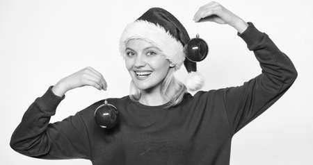 It is time to decorate christmas tree. Decoration pleasant routine. Woman santa hat hold two balls decor ornament. Add decorative details. New year decor concept. Christmas tree decor ideasの写真素材