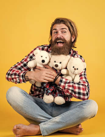 embrace with love. male feel playful with bear. brutal mature hipster man play with toy. happy birthday. being in good mood. happy valentines day. cheerful bearded man hold teddy bear. Loveの写真素材