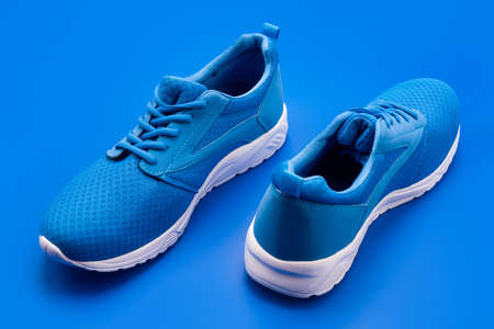 pair of comfortable sport shoes. sporty blue sneakers. shoes on blue background.の写真素材