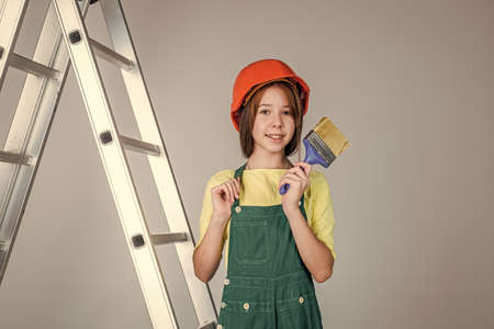kid build construction. engineer teen is construction worker. international workers day. painter on stepladder. girl in helmet plays builder. building and renovating. I think I can help youの写真素材