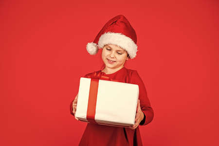 Best time. big christmas sale. child santa hat hold gift box. boxing day concept. all i dream about. happy new year. winter holiday and xmas joy. seasonal shopping discount. small girl carry presentの写真素材
