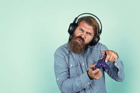need to win. relax at home. console controller joystick. gaming in earphones. mature man gamer play computer games. guy with beard playing video games. brutal caucasian hipster with moustacheの写真素材