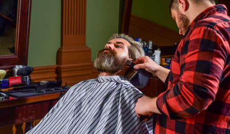 Got to shave. shaving. Hairstylist in barbershop. man in hair salon with hipster haircut. beard and mustaches. Professional hairstylist in barbershop interior. Portrait of stylish man beardの写真素材