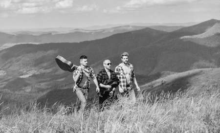 music is my religion. men friends with guitar. friendship. western camping. campfire songs. men with guitar in checkered shirt. hiking adventure. cowboy men. group of people spend free time togetherの写真素材