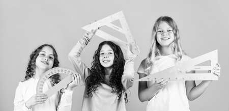 School friendship. Group studying. Teamwork and help. Developing cognitive skills. Study together. Clever kids. Education concept. School students learning geometry. Girls with triangle rulerの写真素材
