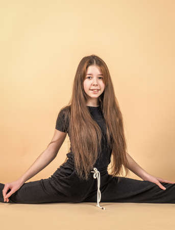 cheerful teen girl sit in split, stretchingの写真素材